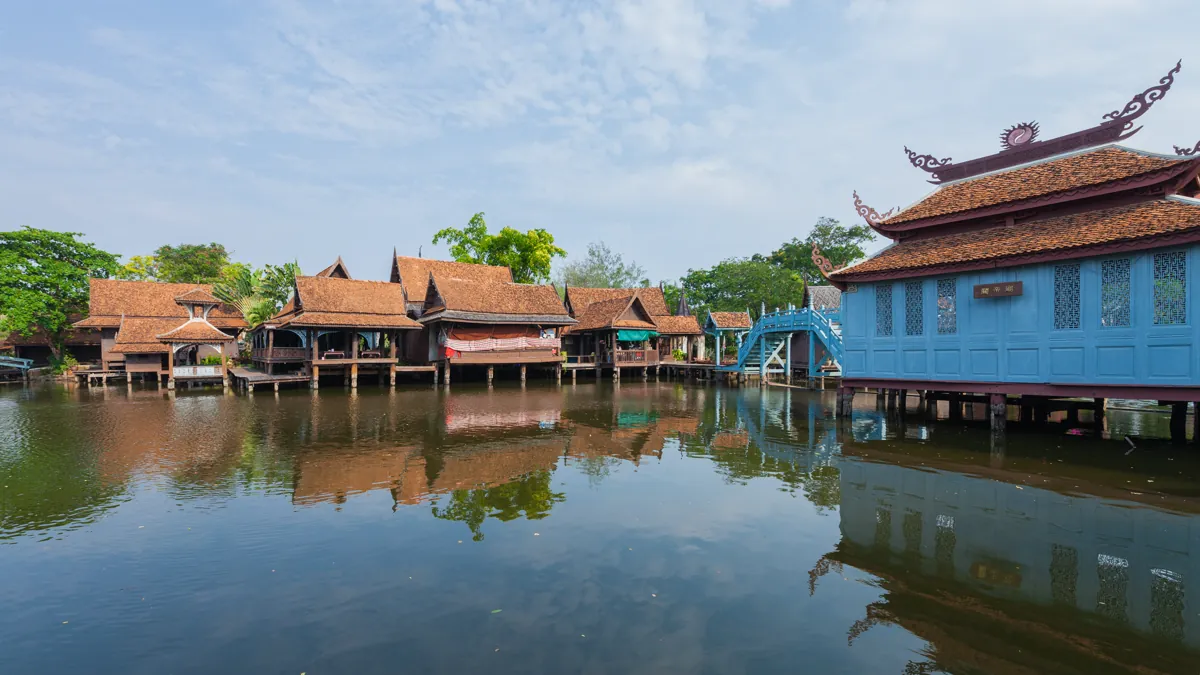 Wooden houses and reflections at the Floating Market inside Ancient City Bangkok