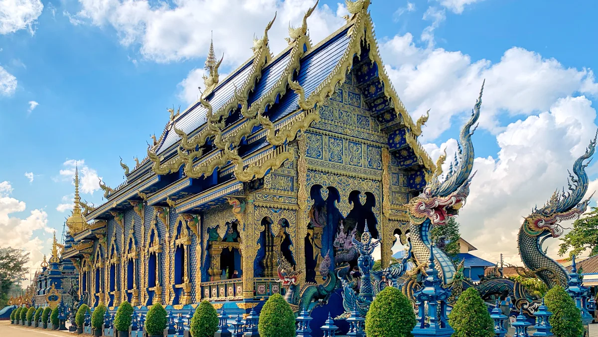Blue and gold exterior of Wat Rong Suea Ten in Chiang Rai