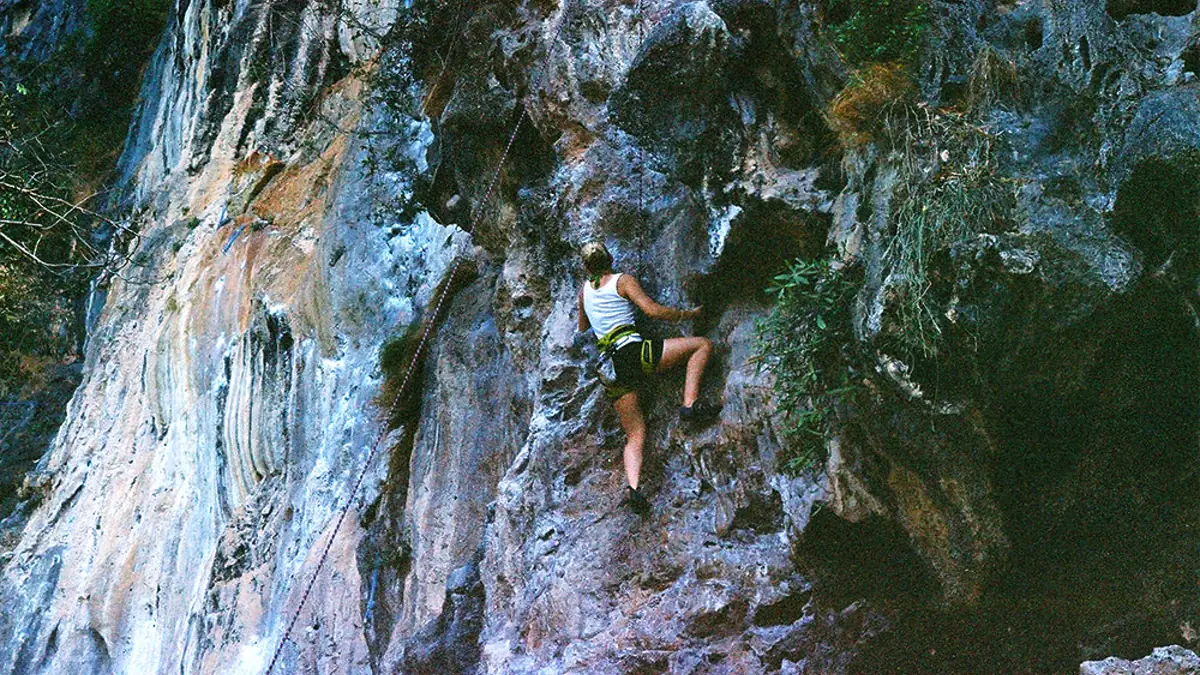 A climber moving up a bolted limestone route at Railay Beach