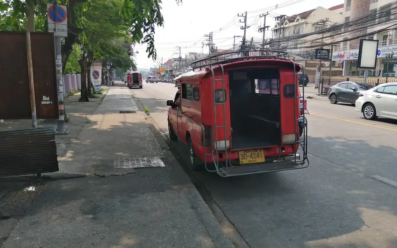 Red songthaew waiting near Chiang Mai University on the route toward Doi Suthep